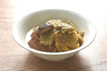 boiled pickled cabbage and bitter cucumber with tofu topping black mushroom in Chinese herb soup on bowl 