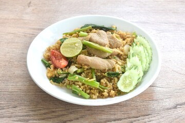 fried rice solf fermenting pork in black sweet soy sauce with slice cucumber couple lemon on plate 