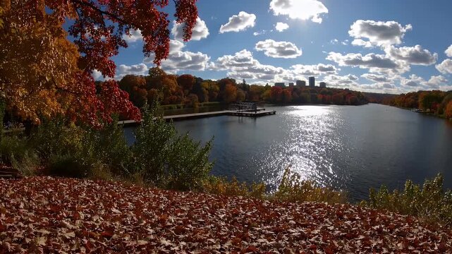 A stunning lakeside view of Lake Harriet captured on a clear autumn afternoon with colorful foliage fishing dock and skyline perfect for nature seasons and urban escape visuals