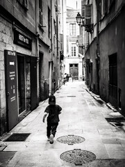 Curious Child Wanderer Exploring Quaint Narrow Parisian Alleyway in Urban Black and White Setting