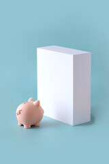 Financial planning concept still life. One piggy bank facing an empty wall. Blue background.
