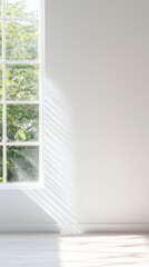 Fototapeta premium Bright, minimalist white room with large window showcasing natural light and dynamic shadows, offering a serene view of lush green trees and tranquil nature.