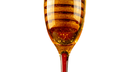 Honey dripper with flowing honey on a transparent background
