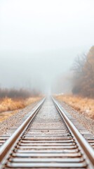Fototapeta premium Misty Autumn Railway Tracks Vanishing into Foggy Horizon: A Serene Rural Journey Through a Tranquil, Atmospheric Landscape with Leading Lines