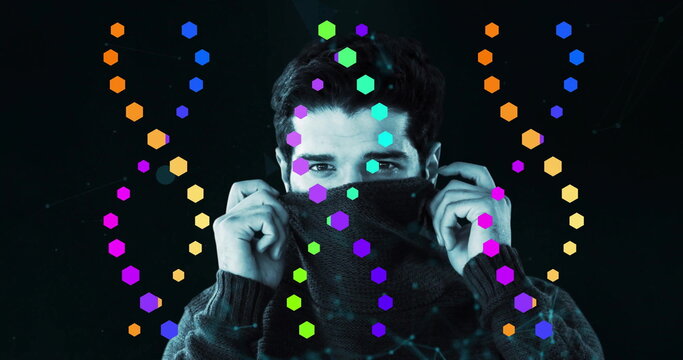 Pulling sweater collar, adult male covering lower face in tech studio, with neon hexagons