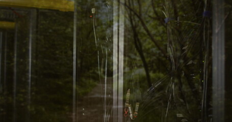 Fototapeta premium Showing tangled black cables behind glass cabinet at forest with zip-ties reflection, copy space