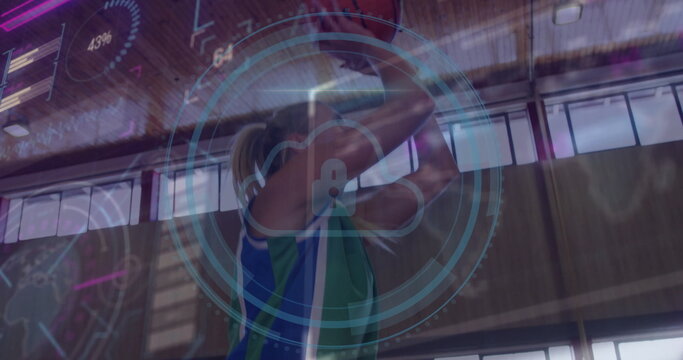 Female athlete holding basketball overhead in sports hall, with digital overlay and jersey