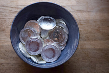 bowl full of silver coins shining 