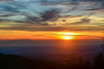 Vibrant sunrise in shades of gold, orange, and fiery red over a vast, expansive landscape in a warm, ethereal glow. Concepts of new beginnings, hope, awakening, tranquility, and the profound beauty