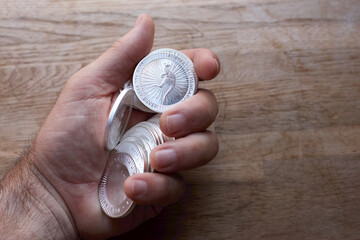 hand holding a bunch of pure silver coins