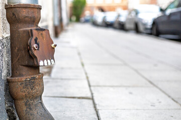 Rusty Drainpipe on Urban Street – Close-Up with Shallow Depth of Field