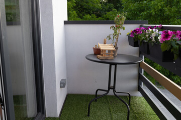 Fototapeta premium Small outdoor balcony garden with table and potted plants