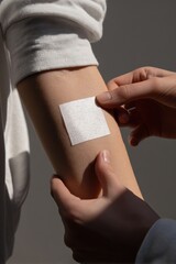 Obraz premium Applying medical patch on arm: healing, first aid, and skin care concept