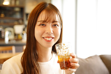 笑顔でアイスティーを飲む女性