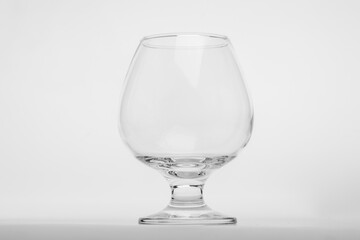 An empty, clear brandy or cognac glass (snifter) isolated on a clean white background.