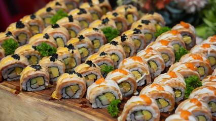 Fresh and healthy Japanese sushi rolls with salmon, rice, and fresh vegetables on a white plate