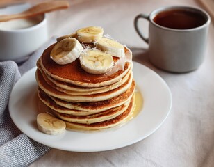 cozy breakfast pancakes stack with banana coconut cream and coffee mug homemade morning comfort food on white plate peaceful hygge lifestyle concept