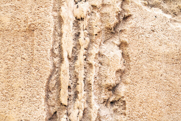 Sand stone wall ridged textured gritty yellow wet dry background