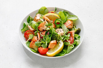 Healthy salad with pieces of baked salmon and green lettuce and tomatoes.
Fresh diet dinner meal. Fish green summer salad. Vitamin food concept.