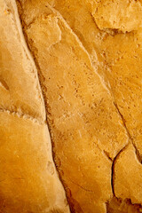 Sand stone wall ridged textured gritty yellow wet dry background