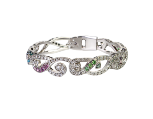 a shiny bracelet sits on a glossy, white surface. the jewelry features a silver colored metal frame intricately designed with swirling patterns and negative spaces