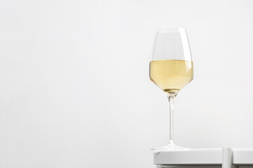 White wine in rich glass on a white round table. Minimalism. Elegant