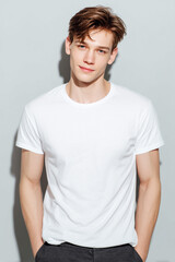 Fototapeta premium A beautiful male model wearing a tight small size white t-shirt. A product shot for fashion and apparel. best use for mockup