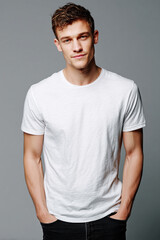 Fototapeta premium A beautiful male model wearing a tight small size white t-shirt. A product shot for fashion and apparel. best use for mockup