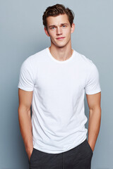 Fototapeta premium A beautiful male model wearing a tight small size white t-shirt. A product shot for fashion and apparel. best use for mockup