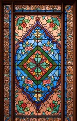 A colorful stained glass window featuring intricate floral designs and geometric patterns, enhancing the beauty of the surrounding architecture.