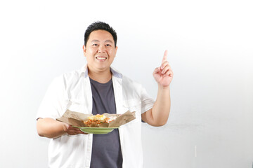 Happy Adult young handsome Asian guy enjoy eating traditional authentic Indonesian Fried Rice