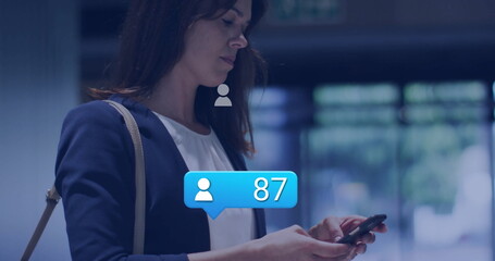 Woman checking smartphone with tan shoulder bag in lobby, blue notification showing 87, copy space