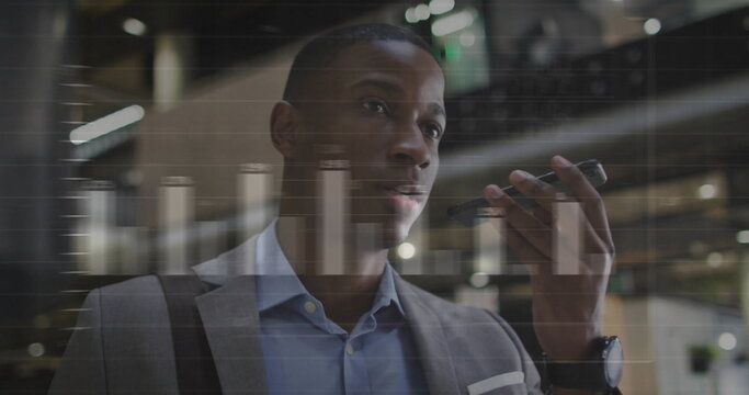 Speaking businessman recording voice message on smartphone in office lobby, with analytics overlay