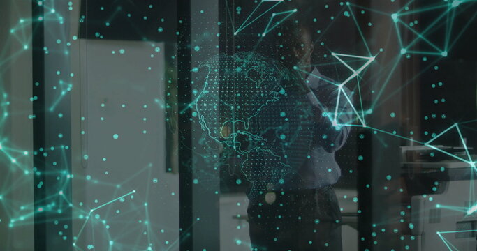 Businessman projecting digital network overlay with globe and nodes in office with glass partition - Powered by Adobe