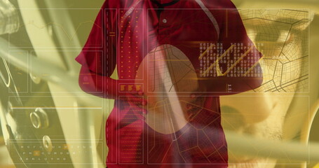 Standing male wearing red jacket crossing arms in car cabin, digital panels showing charts