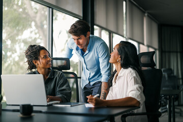 Group of young multi-ethnic startup business team collaborating on project in modern office