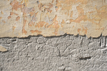 Detailed close up of chipped painted wall showing exposed concrete piece