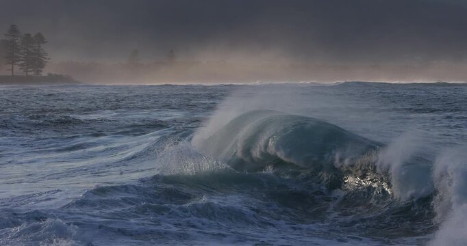 Two opposing ocean waves collide and flare over a shallow reef on the East Coast of New South Wales, Australia. Captured in slow motion during a large storm swell event.
