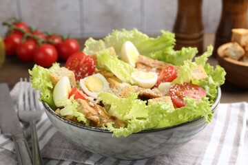 Delicious salad with croutons and ingredients on table, closeup