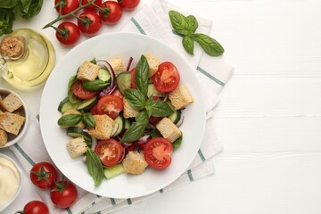 Delicious salad with croutons and ingredients on white wooden table, flat lay. Space for text