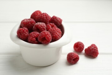Tasty fresh ripe raspberries on white wooden table, closeup