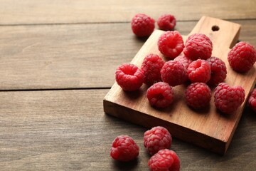 Tasty fresh ripe raspberries on wooden table, closeup. Space for text