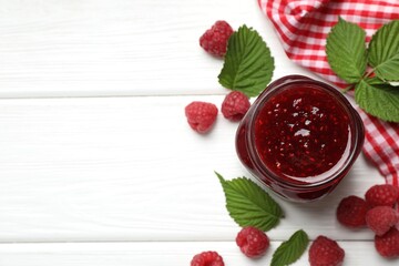 Tasty jam, fresh ripe raspberries and leaves on white wooden table, flat lay. Space for text