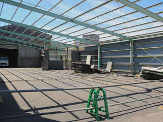 An empty warehouse with its roof removed for demolition.