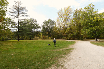 Active lifestyle with woman walking pet dog during Indiana fall season outdoors.