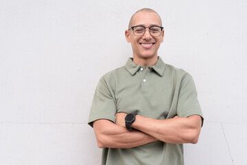 Hispanic bald man in polo shirt isolated on white background with arms crossed