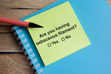 Are you having sebaceous filament write on sticky notes isolated on Wooden Table. A person is answering question concept