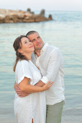 Obraz premium Couple in love at sea on the beach in summer. Husband and wife. Dad and mom