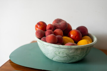 Fruit bown apricots nectarines peaches lemons pink red orange healthy food summer food white background