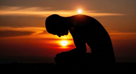 Silhouette in Prayer at Sunset: A contemplative figure in silhouette kneels in prayer against a vibrant sunset, evoking a sense of faith, hope, and quiet reflection.